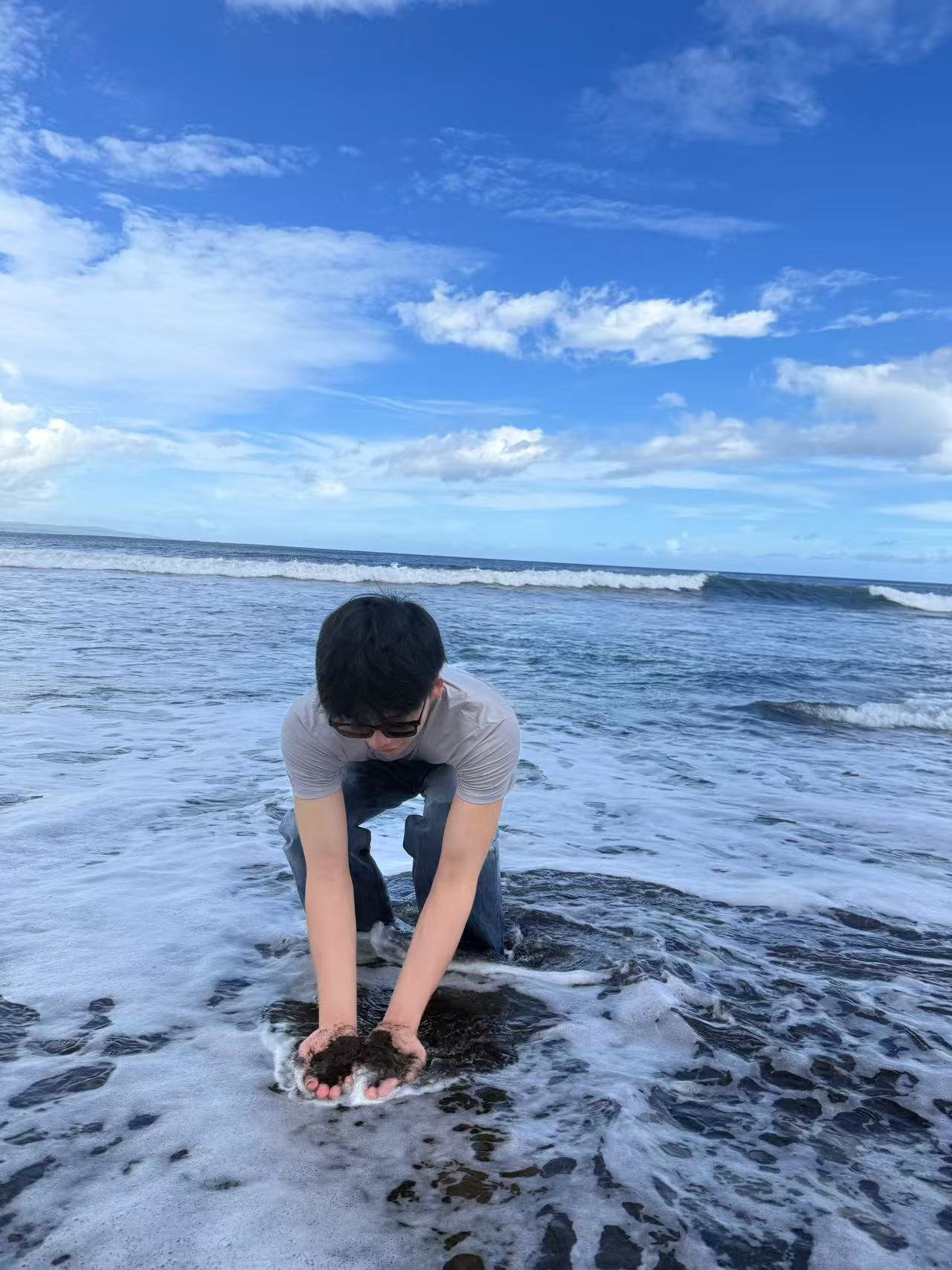 On the beach, holding sand